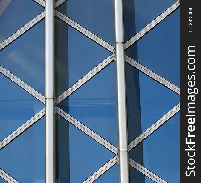 Part of a glass wall framed by steel beams. Part of a glass wall framed by steel beams