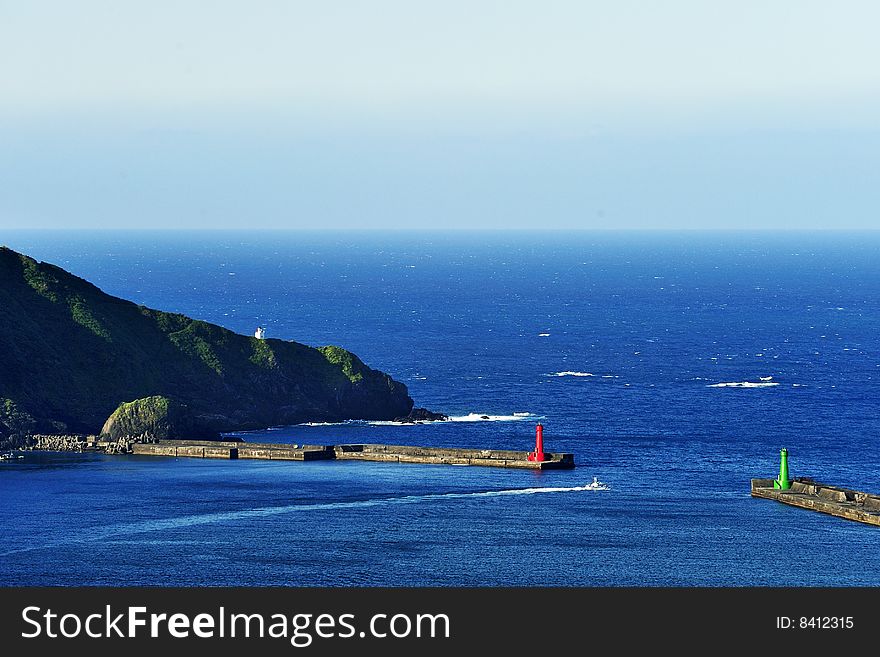 A speedboat passing between two lighthouses