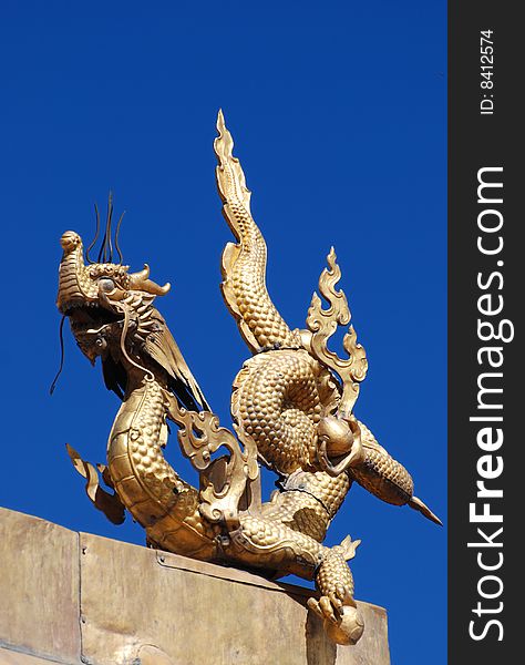 Golden Buddhism Dragon over blue sky. Golden Buddhism Dragon over blue sky