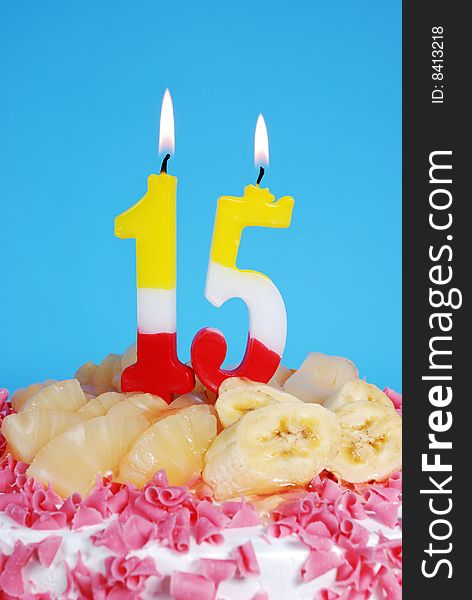 Birthday cake with fruits and burning candle vertical