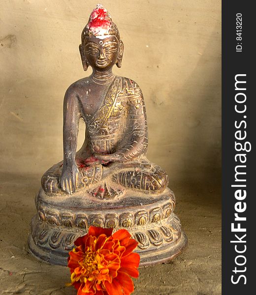 Antique sculpture of lord Buddha with marigold flower. Antique sculpture of lord Buddha with marigold flower