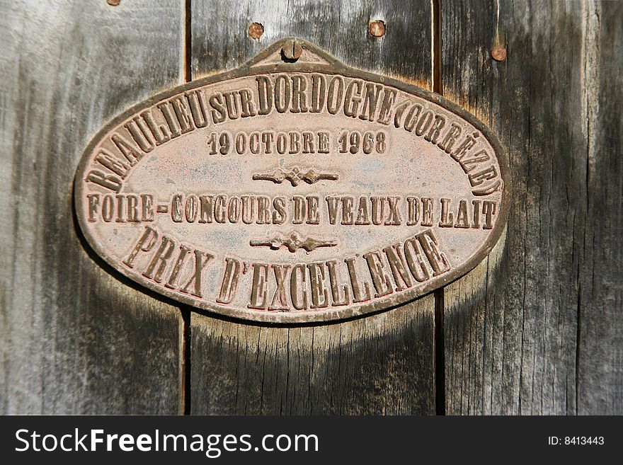 Prize medal from cattle competition hung on barn door in correze, france