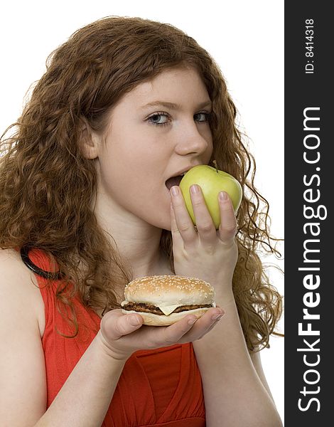 Fastfood or apple, female teenager with red hair choose food