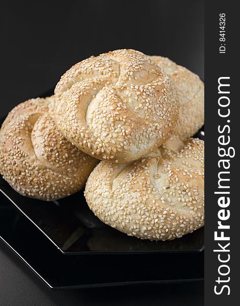 White bread with sesame on a black plate
