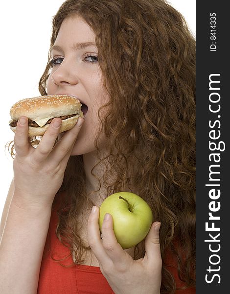 Fastfood or apple, female teenager with red hair choose food