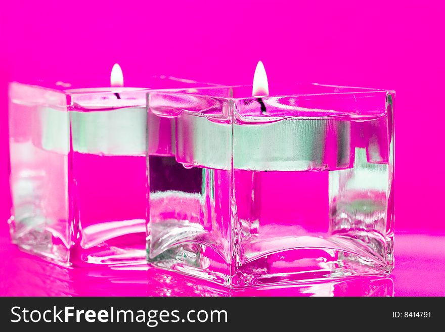 Pink candles in glass with water