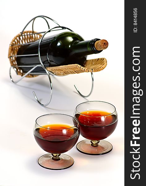 Wine bottle in basket and two glasses