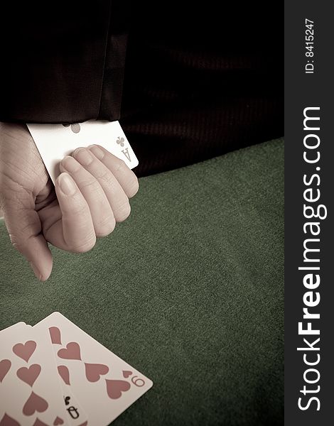 Woman with a playing card up her sleeve and cards on the table. Woman with a playing card up her sleeve and cards on the table