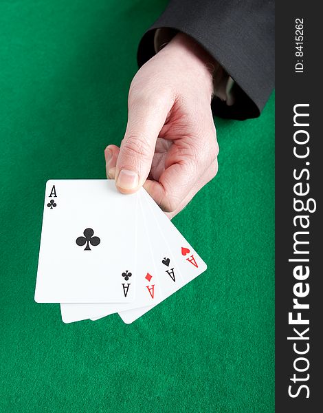 Card player holding all four aces on a green cloth. Card player holding all four aces on a green cloth