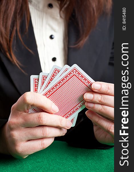 Woman holding 5 red cards about to place a card on the table. Woman holding 5 red cards about to place a card on the table