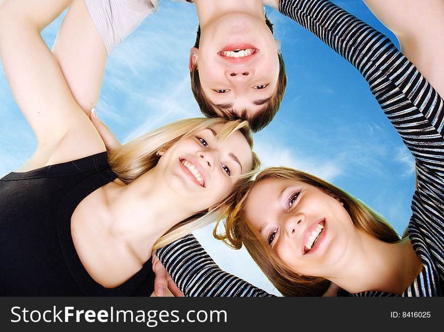 Three happy young friends under blue sky. Three happy young friends under blue sky