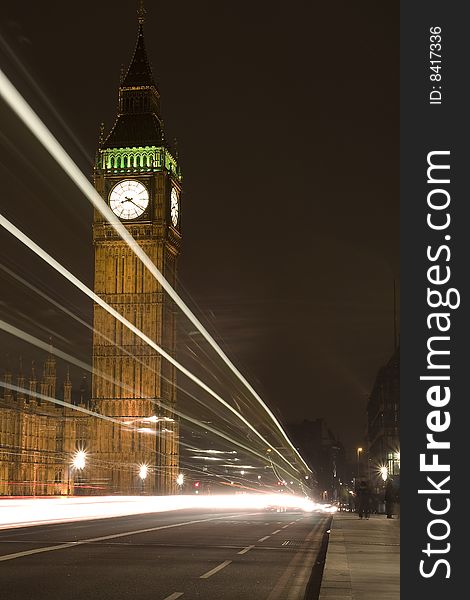 The famous Big Ben at night. The Big Ben is located in London England. The white stripes are from cars that drive by.