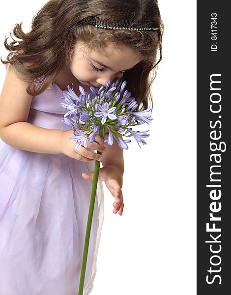 A young girl smelling a large african lily - agapanthus. A young girl smelling a large african lily - agapanthus