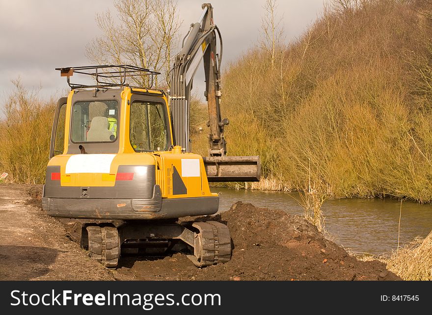 Mini digger working moving earth