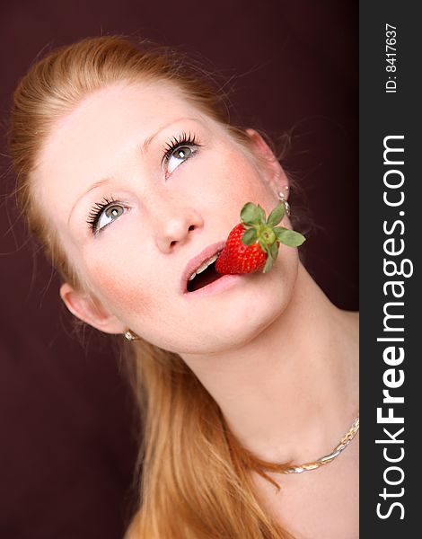 Blond woman with strawberry in mouth. Blond woman with strawberry in mouth