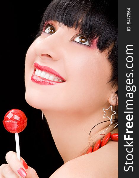 Sweet woman with candy on black background