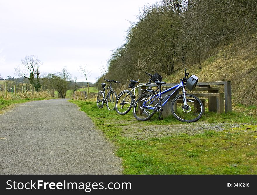 Three bikes resting next to a rural cycle track