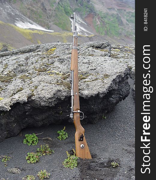 Rifle on the black sandy beach of Jan Mayen island