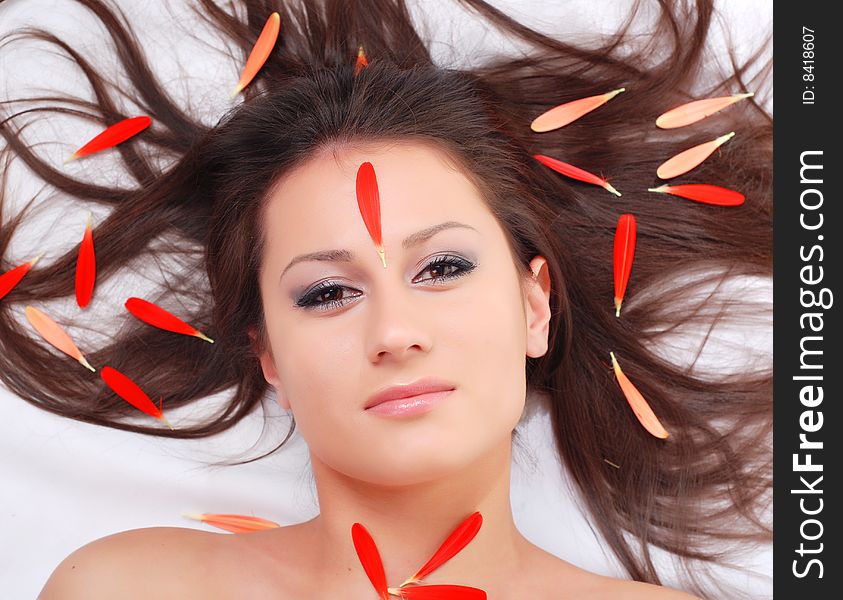 Portrait of a beautiful woman with red petals