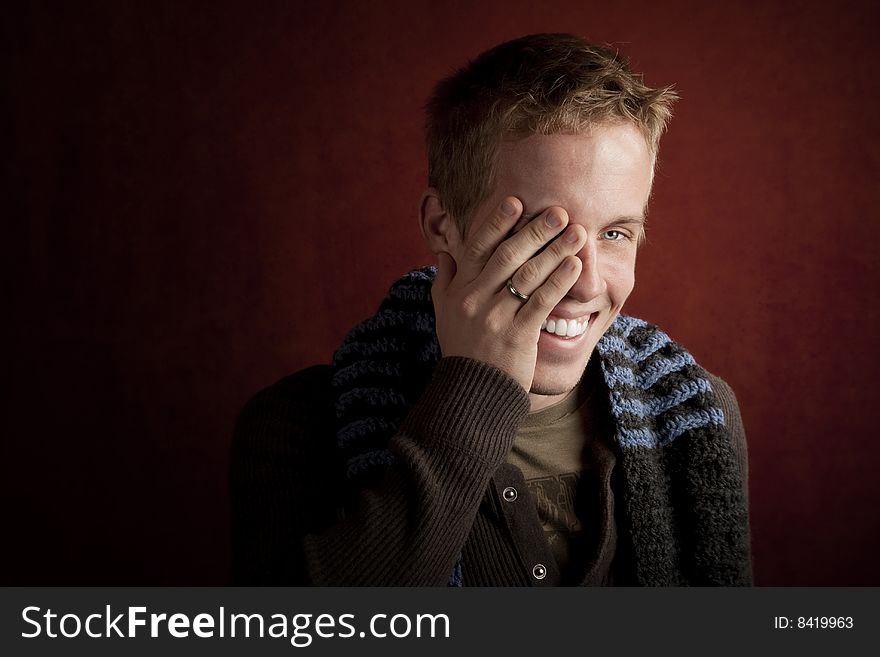Young man covering face with his hand. Young man covering face with his hand