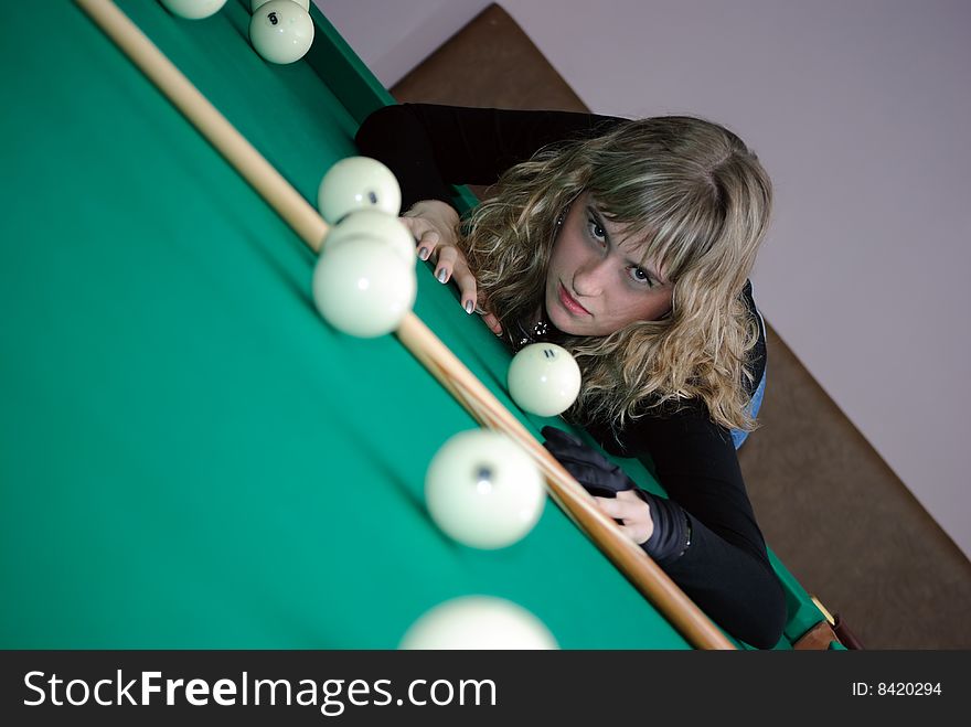The girl with a passionate sight lays on a billiard table. The girl with a passionate sight lays on a billiard table