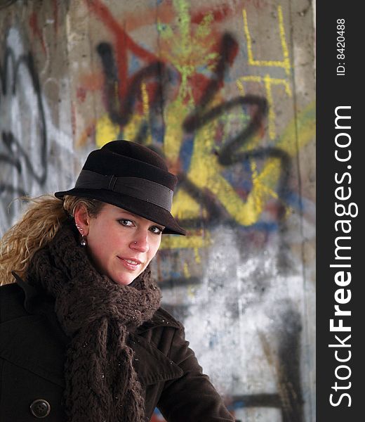 Girl with brown hat with graffiti background behind