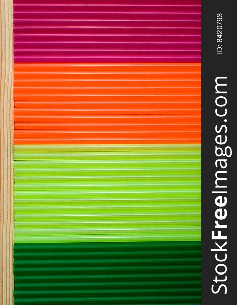 Arrangement of colorful straw on a wooden board as a background. Arrangement of colorful straw on a wooden board as a background