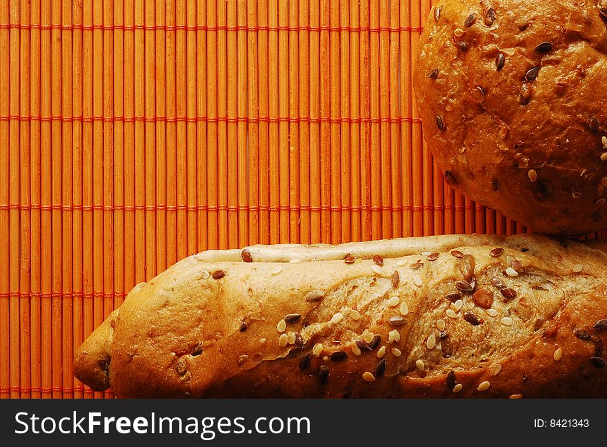 Fresh bread over orange bamboo mat. Fresh bread over orange bamboo mat