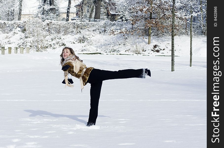 A young woman is playing in a garden in winter. A young woman is playing in a garden in winter
