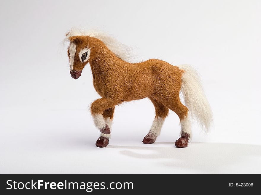 Cute horse toy with beautiful mane prancing on white background. Cute horse toy with beautiful mane prancing on white background