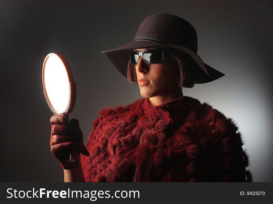 Portrait of a glamorous looking woman with a mirror. Portrait of a glamorous looking woman with a mirror