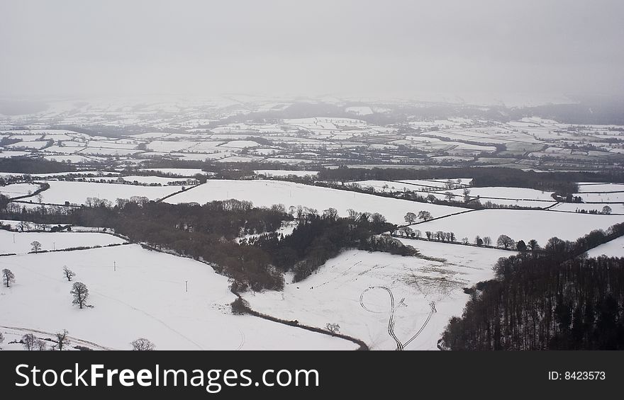 English countryside shot from a plane during a snow storm. the snow flakes create a bizarre flat light and romantic mistiness in the air. English countryside shot from a plane during a snow storm. the snow flakes create a bizarre flat light and romantic mistiness in the air