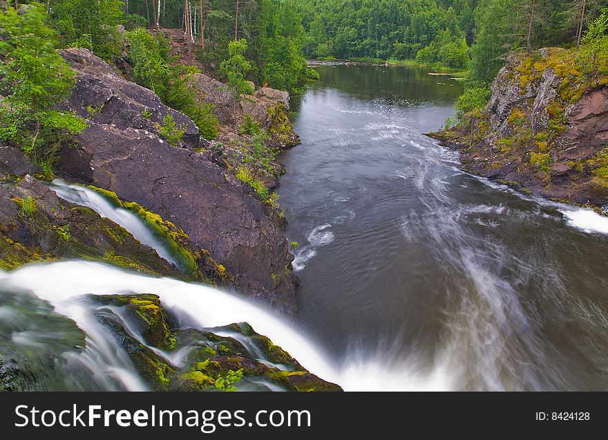 Waterfall and green forest near lake. Waterfall and green forest near lake