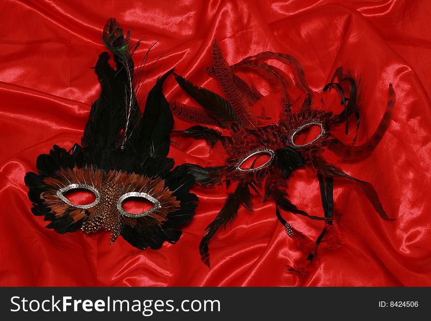 Two carmival masks on red silk. Two carmival masks on red silk