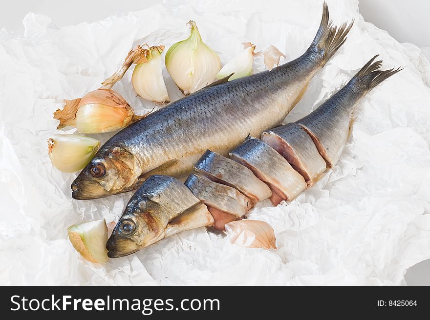 Two herrings with onion on paper background. Two herrings with onion on paper background