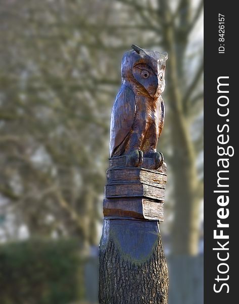 Felled tree carved into a statue of a wise old owl. Felled tree carved into a statue of a wise old owl