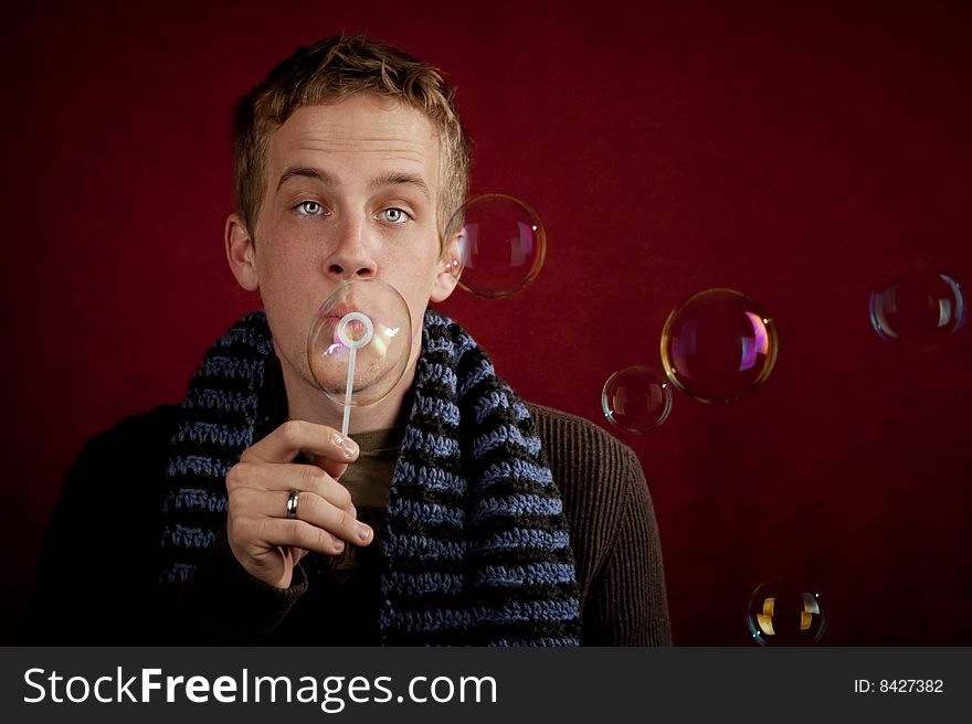 Handsome young blonde man blowing a bubbles. Handsome young blonde man blowing a bubbles