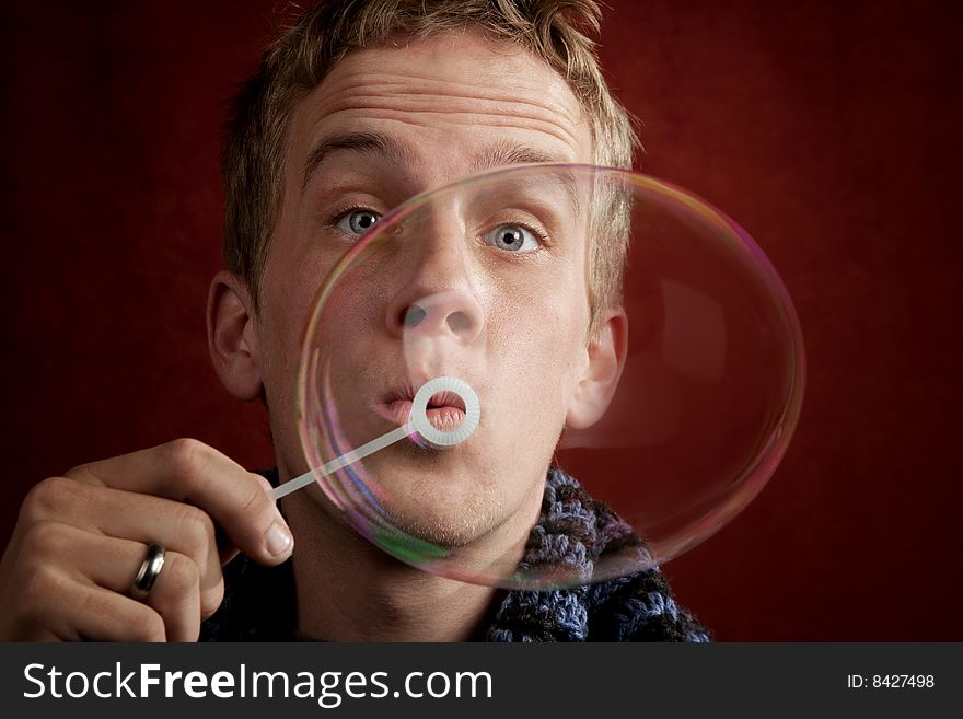 Handsome young blonde man blowing a bubble. Handsome young blonde man blowing a bubble