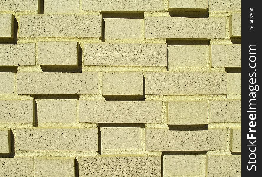 A pastel yellow multi-layered and multi-sized brick wall. A pastel yellow multi-layered and multi-sized brick wall.