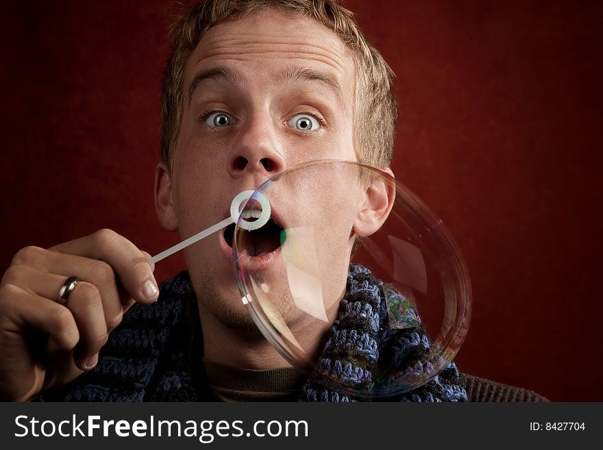 Handsome young blonde man blowing a bubble. Handsome young blonde man blowing a bubble