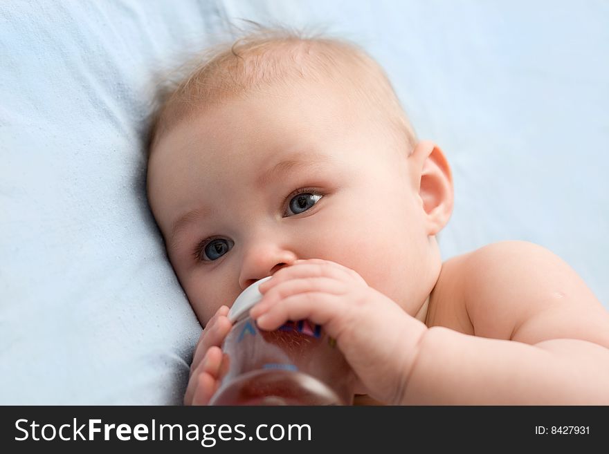 Adorable little girl drinking from plastic bottle