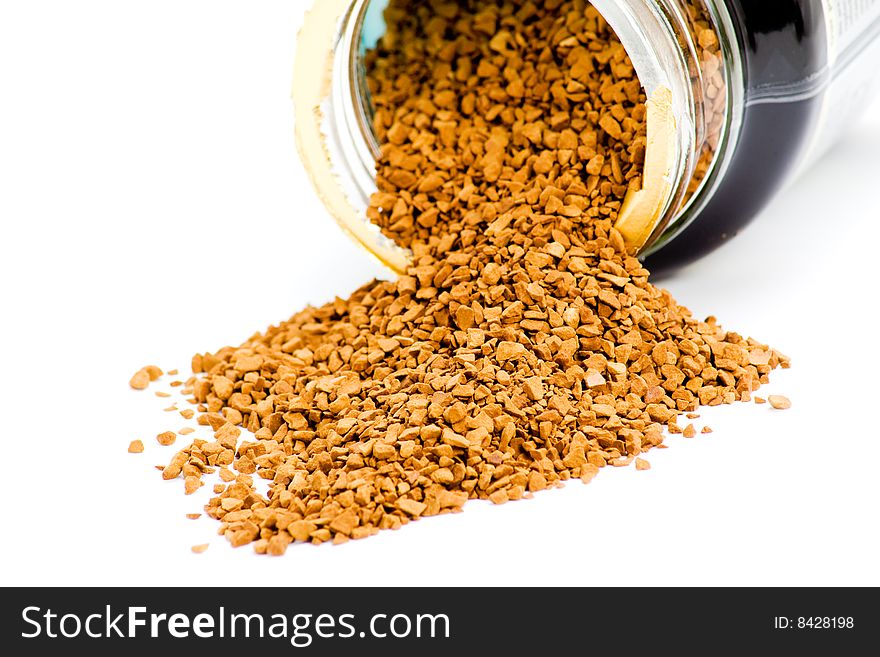 Instant coffee granules spilled from container on white