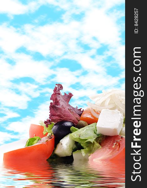 Greek Salad with Tomato and Onions on a Blue Sky Background