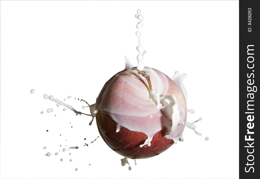 An apple covered by milk splash on white background. An apple covered by milk splash on white background