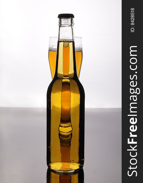 A bottle and a glass of tasty gold beer. A bottle and a glass of tasty gold beer