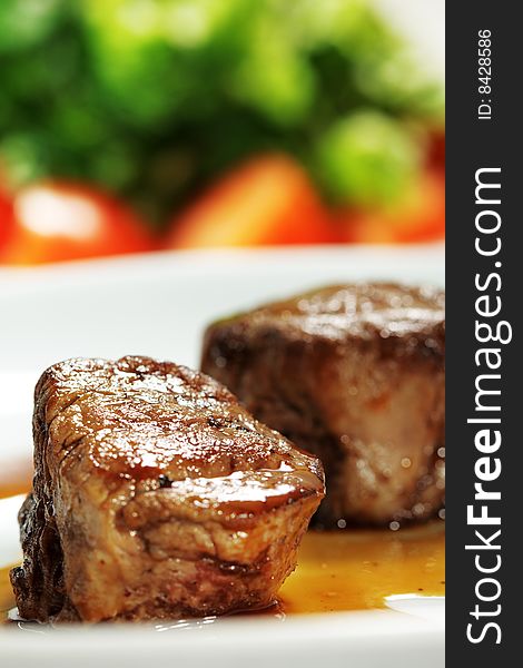 Veal Medallions with Tomato and Greens on a Background. Selective Focus