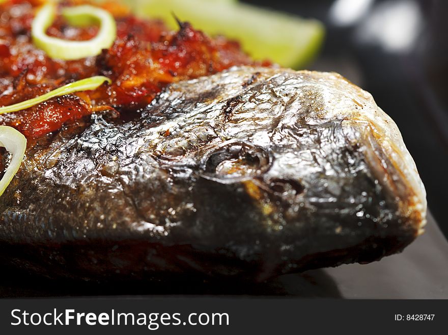 Thai Dorado with Lemon Slice on a Black Dish