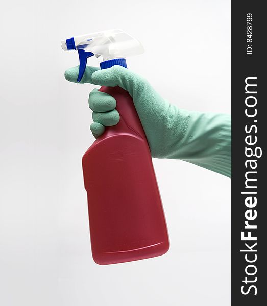 Cleaning - Hand with protection gloves holding red bottle with fog head