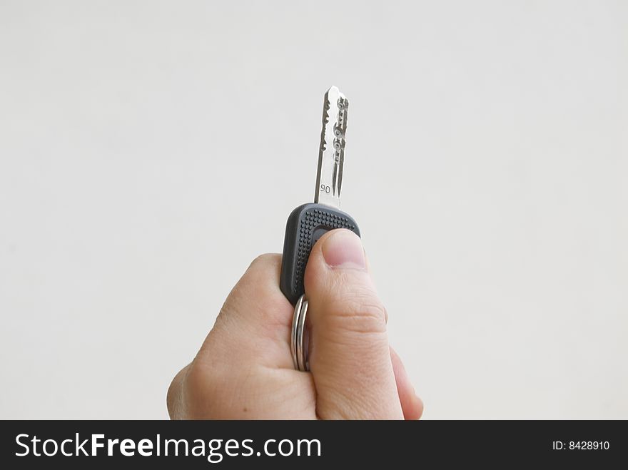 Male arm retaining key on white background.