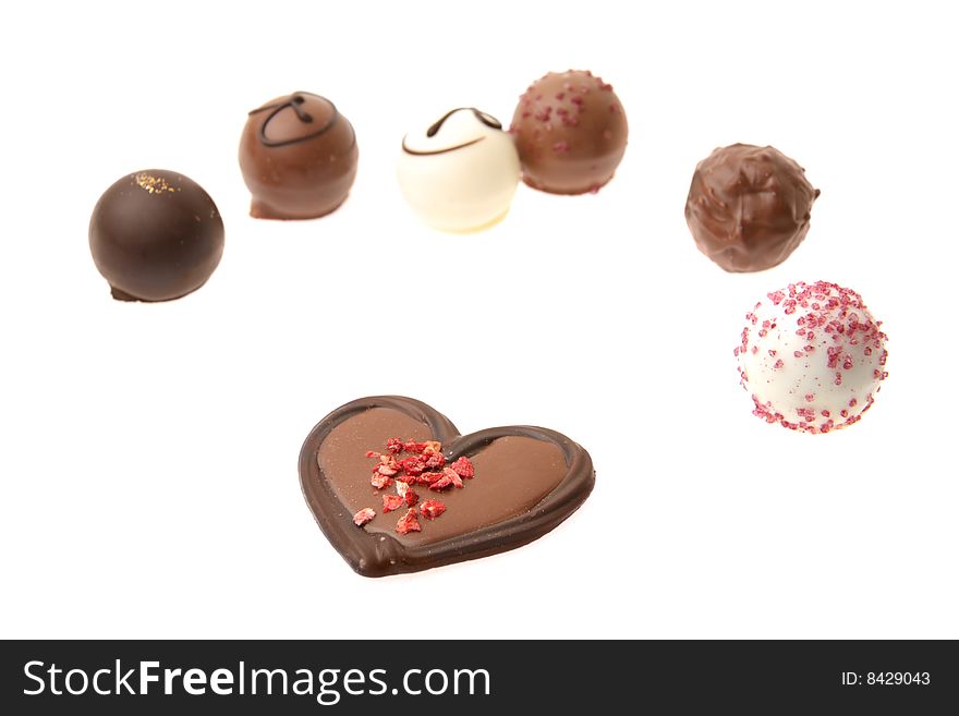 Chocolate heart and other chocolate pralines isolated on the white background